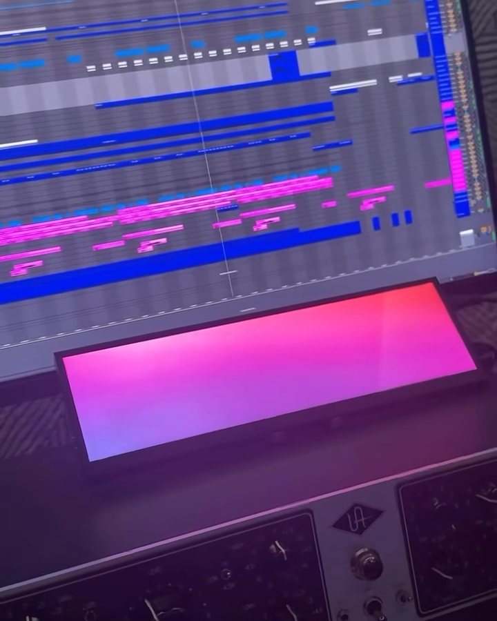 An Ableton arrangement on the screen above a pink light bar